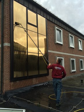 Mitarbeiter putzt Fenster
